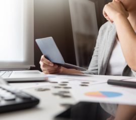 Woman holding her passbook is stressed over her unpaid debts.