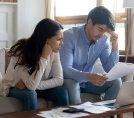 Sad couple thinking about their unpaid debts planning to file for bankruptcy.